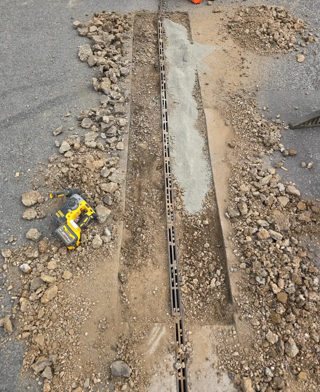 Freshly bedded channel drain in an excavated trench